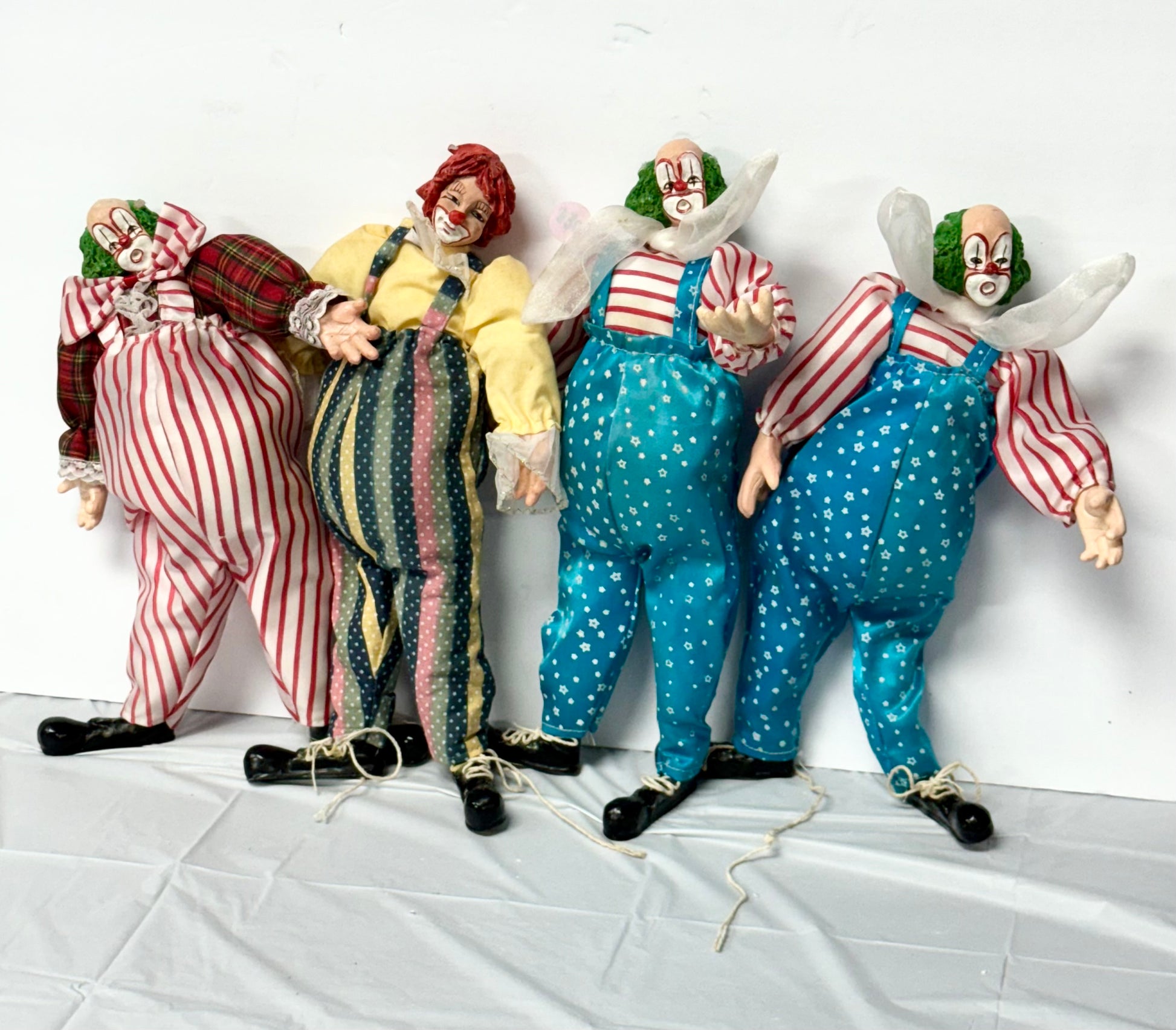 Set of 4 Vintage Porcelain Clown Dolls – Collectible Circus Clowns with Fabric Costumes